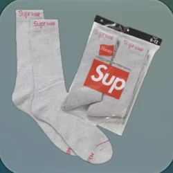 A pair of white crew socks beside their pack